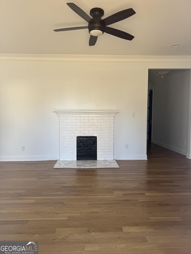 unfurnished living room featuring ceiling fan, ornamental molding, a fireplace, and dark wood-type flooring