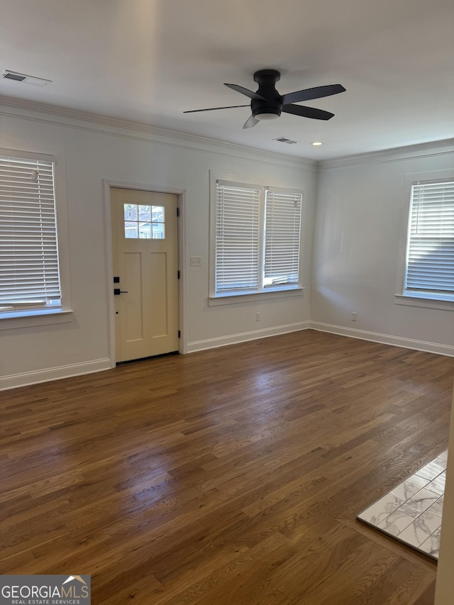 foyer entrance with ornamental molding, ceiling fan, and dark wood-type flooring