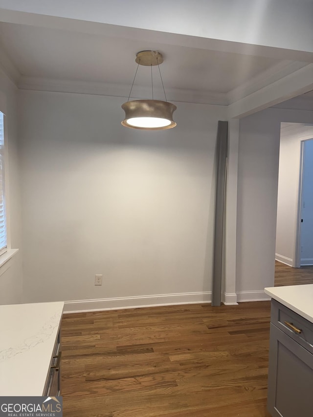 unfurnished dining area with dark hardwood / wood-style floors and ornamental molding