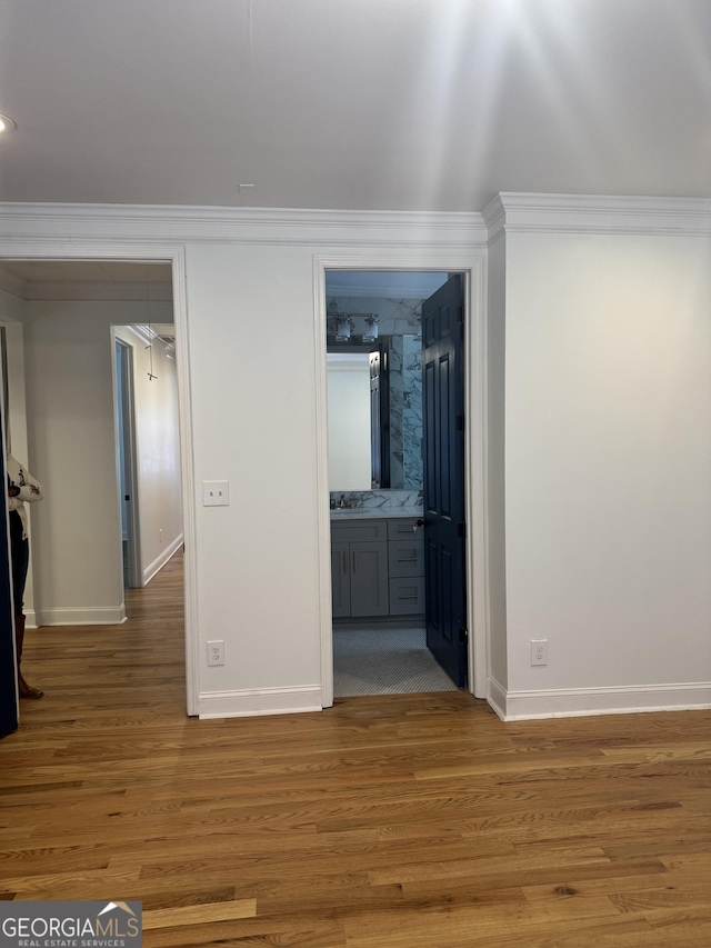 corridor with wood-type flooring and ornamental molding