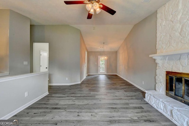 foyer featuring ceiling fan, wood-type flooring, a fireplace, and vaulted ceiling