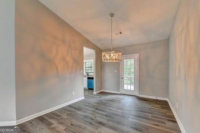 spare room featuring sink, a chandelier, lofted ceiling, and hardwood / wood-style flooring