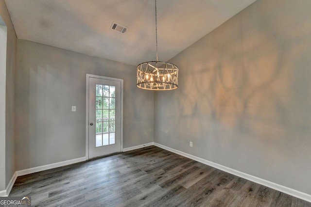 unfurnished dining area with dark hardwood / wood-style floors, an inviting chandelier, and lofted ceiling