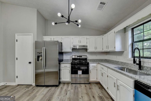 kitchen featuring sink, a notable chandelier, lofted ceiling, white cabinets, and appliances with stainless steel finishes