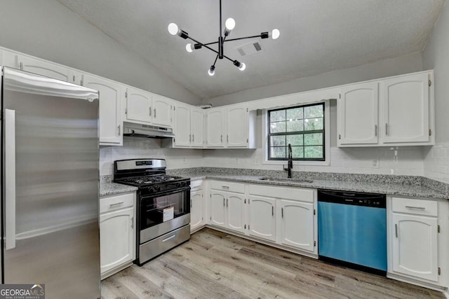 kitchen with sink, light stone counters, lofted ceiling, white cabinets, and appliances with stainless steel finishes