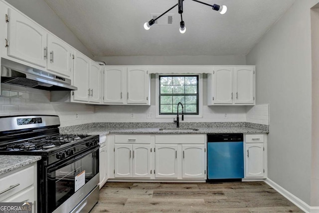 kitchen featuring white cabinets, stainless steel appliances, light stone counters, and sink