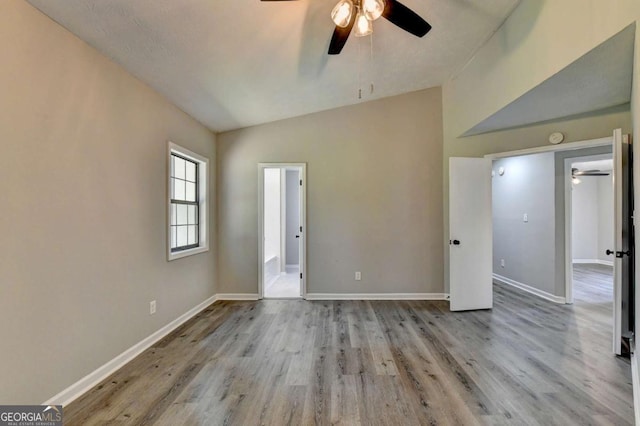 empty room featuring light hardwood / wood-style floors, ceiling fan, and lofted ceiling