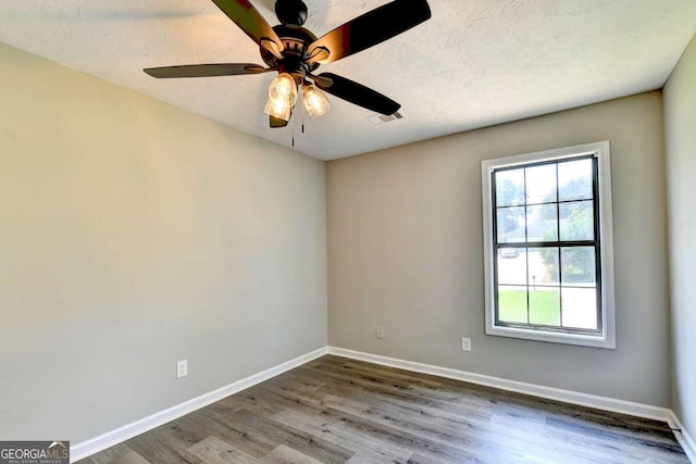 unfurnished room featuring ceiling fan, wood-type flooring, and a textured ceiling