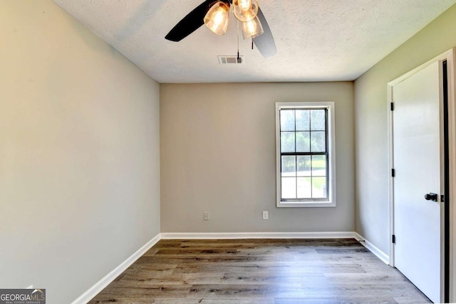 empty room with hardwood / wood-style floors, a textured ceiling, and ceiling fan