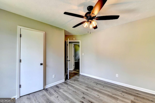 unfurnished bedroom featuring a textured ceiling, light wood-type flooring, and ceiling fan