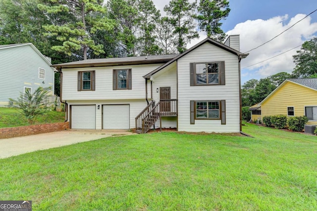 bi-level home featuring a garage and a front lawn