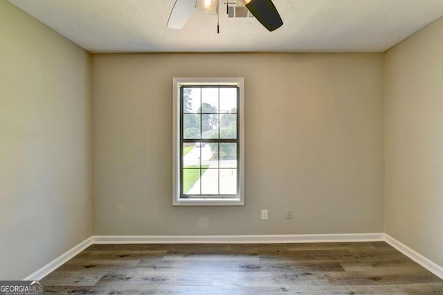 unfurnished room with ceiling fan and dark hardwood / wood-style floors