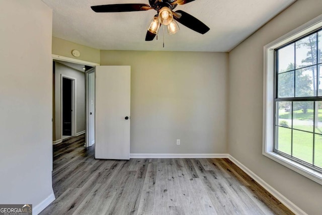 unfurnished room featuring light hardwood / wood-style floors, plenty of natural light, and ceiling fan