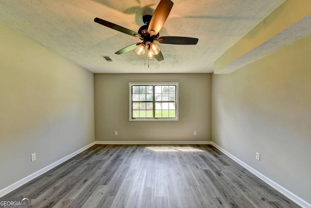 unfurnished room with hardwood / wood-style floors, ceiling fan, and a textured ceiling