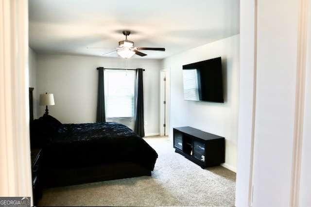 bedroom with ceiling fan and light carpet