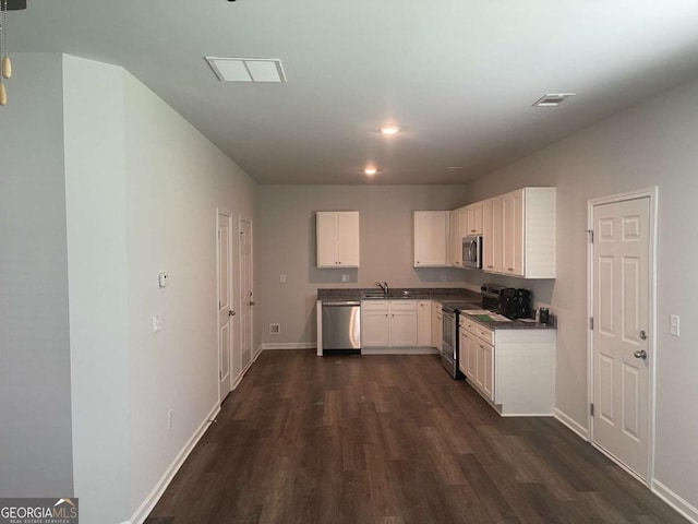 kitchen with white cabinetry, dark wood-type flooring, and stainless steel appliances