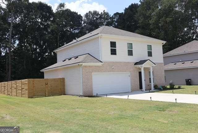 front facade with a garage and a front lawn