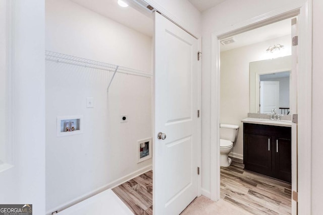 clothes washing area featuring washer hookup, electric dryer hookup, sink, and light hardwood / wood-style flooring