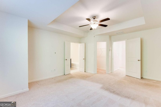 interior space with a tray ceiling and ceiling fan