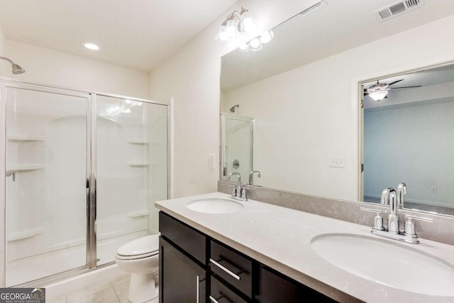 bathroom with vanity, tile patterned flooring, ceiling fan, toilet, and walk in shower