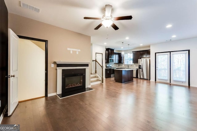 unfurnished living room featuring ceiling fan and hardwood / wood-style floors