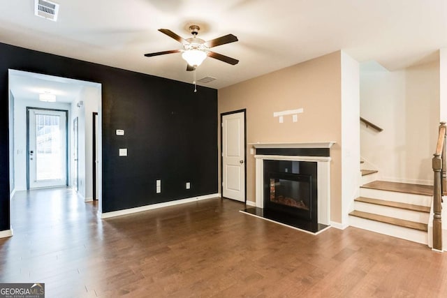 unfurnished living room with ceiling fan and dark hardwood / wood-style flooring