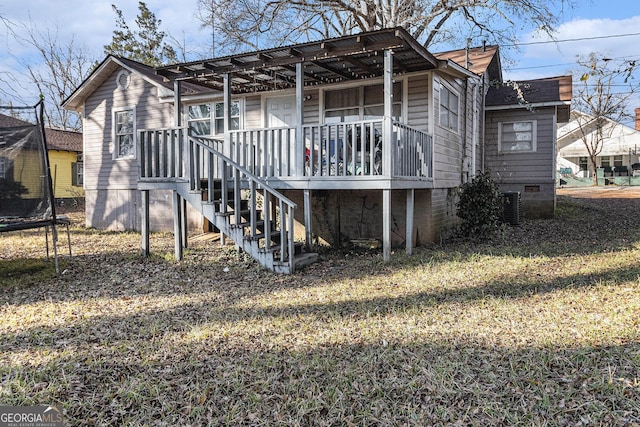 back of house with a yard, cooling unit, and a trampoline