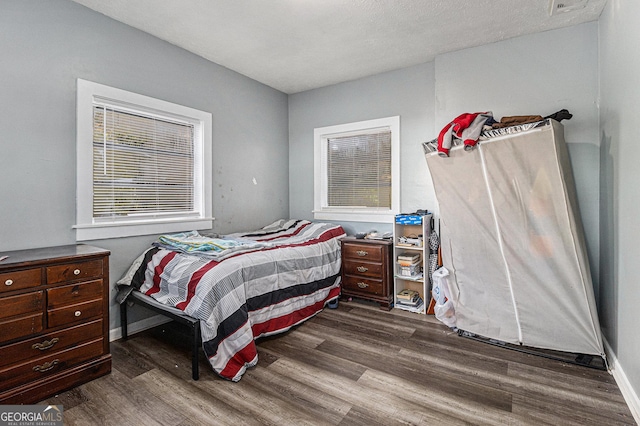 bedroom with dark wood-type flooring