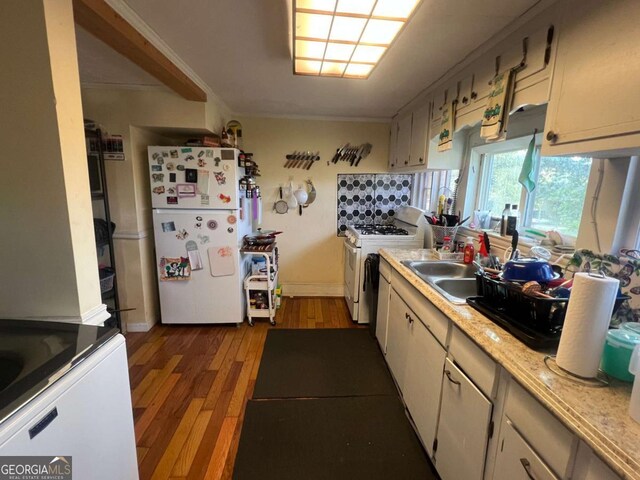 kitchen with dark hardwood / wood-style flooring, tasteful backsplash, white appliances, crown molding, and sink