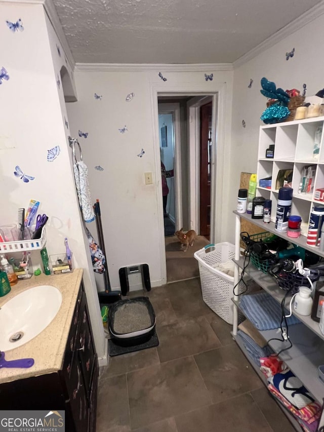 bathroom with a textured ceiling, vanity, and crown molding