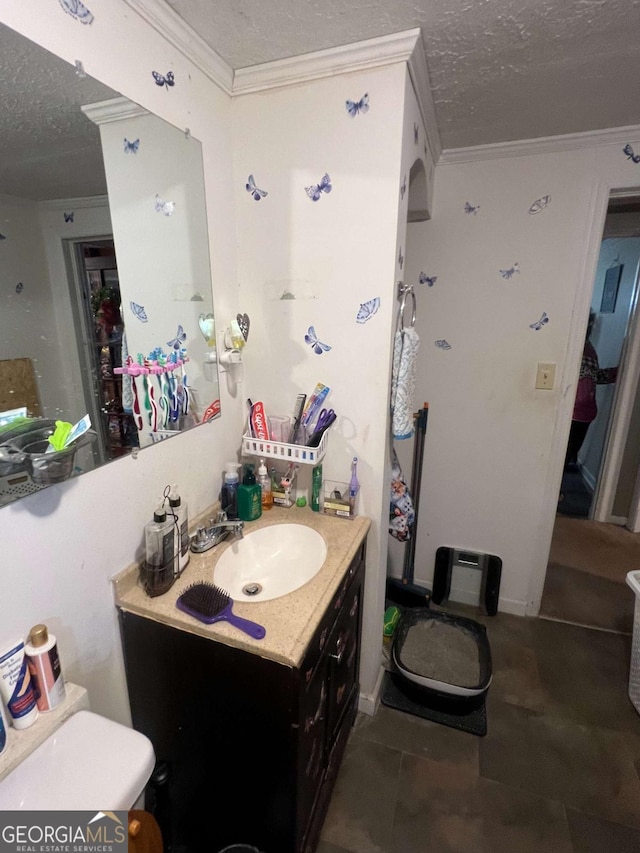 bathroom with tile patterned flooring, a textured ceiling, toilet, vanity, and ornamental molding