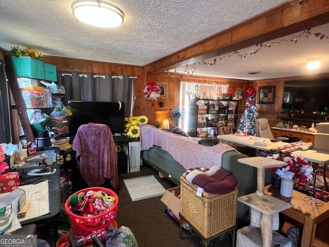 misc room with wooden walls, carpet, and a textured ceiling