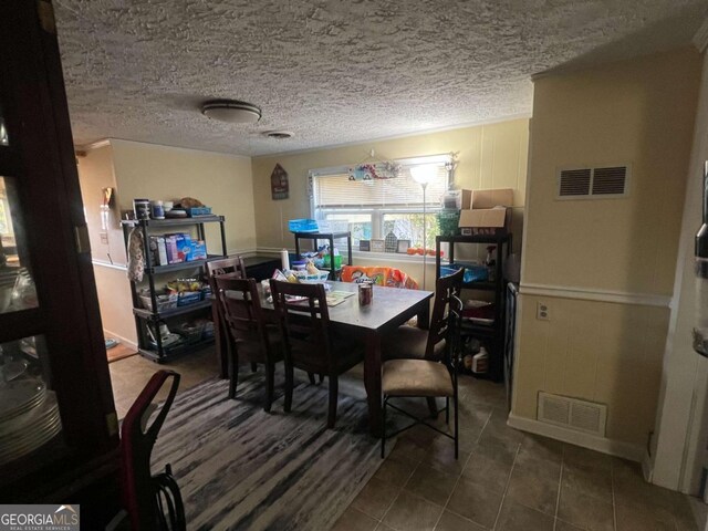 tiled dining space with a textured ceiling