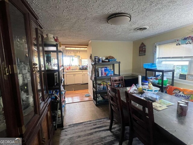 dining room with wood-type flooring and a textured ceiling