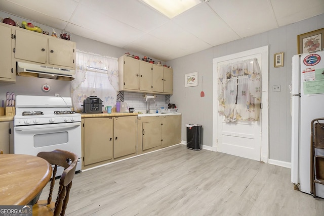 kitchen featuring decorative backsplash, light hardwood / wood-style floors, white appliances, and sink