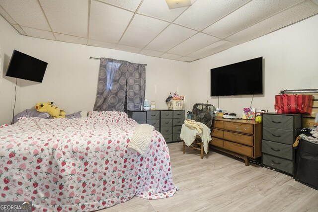 bedroom featuring light hardwood / wood-style floors and a drop ceiling