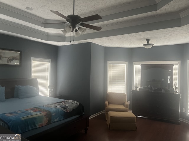 bedroom featuring a textured ceiling, a tray ceiling, and ceiling fan