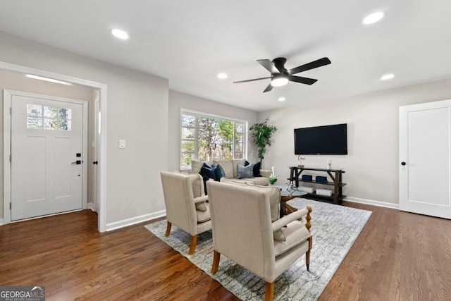 living room with dark hardwood / wood-style floors and ceiling fan