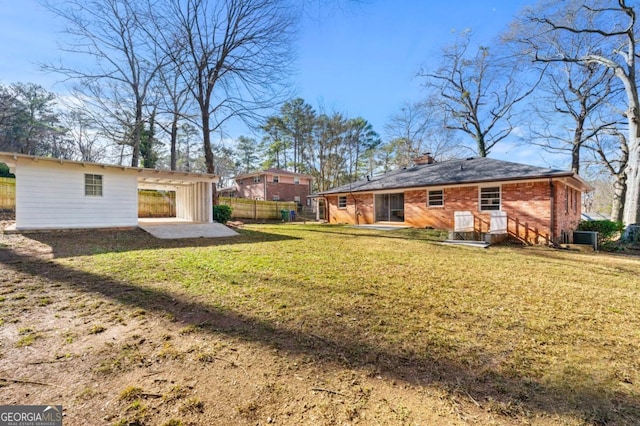 back of property with central AC unit, a yard, and a patio