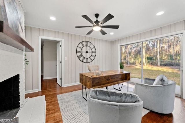 interior space featuring ceiling fan, a fireplace, and hardwood / wood-style floors