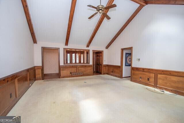 unfurnished living room featuring vaulted ceiling with beams, ceiling fan, and light carpet