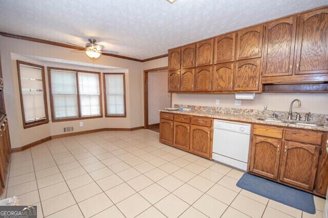 kitchen featuring ornamental molding, a textured ceiling, white dishwasher, ceiling fan, and sink