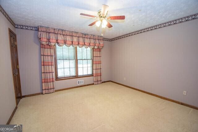 unfurnished room with carpet, a textured ceiling, and ceiling fan