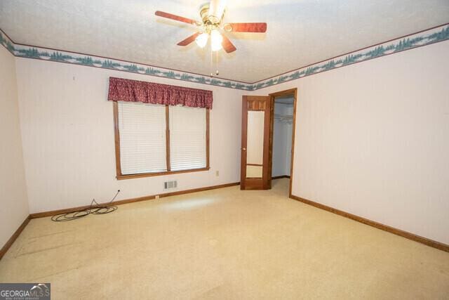 carpeted spare room featuring ceiling fan