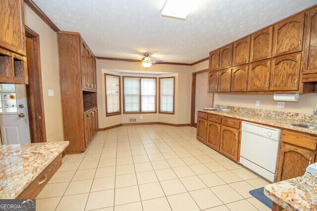 kitchen featuring ceiling fan, sink, white dishwasher, and a textured ceiling