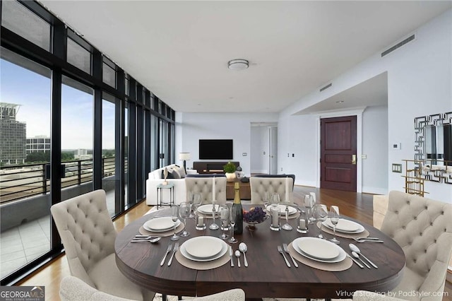 dining area featuring light wood-type flooring and floor to ceiling windows