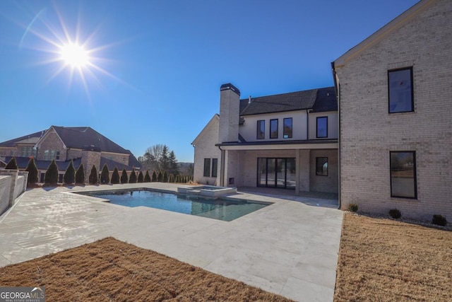 view of swimming pool featuring an in ground hot tub and a patio