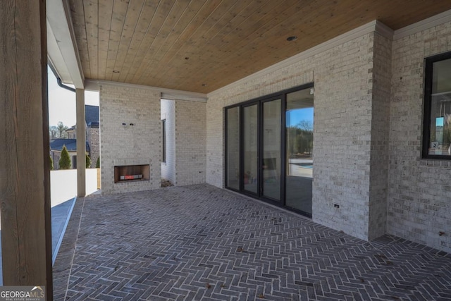 view of patio featuring an outdoor brick fireplace