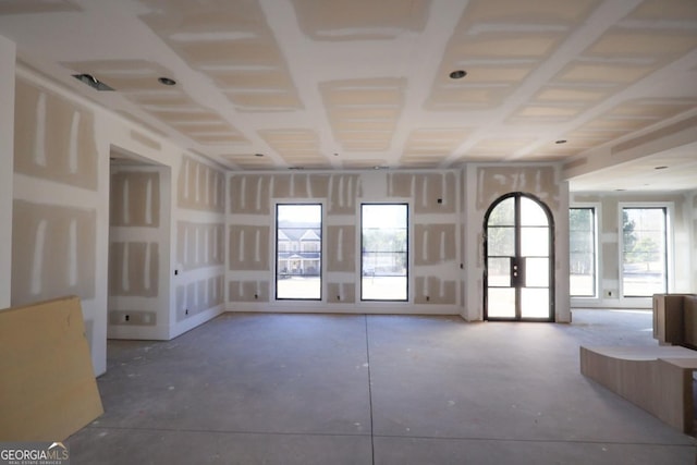 unfurnished living room with concrete flooring and french doors