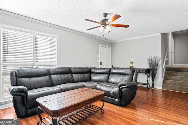 living room with wood-type flooring, a textured ceiling, ceiling fan, and ornamental molding